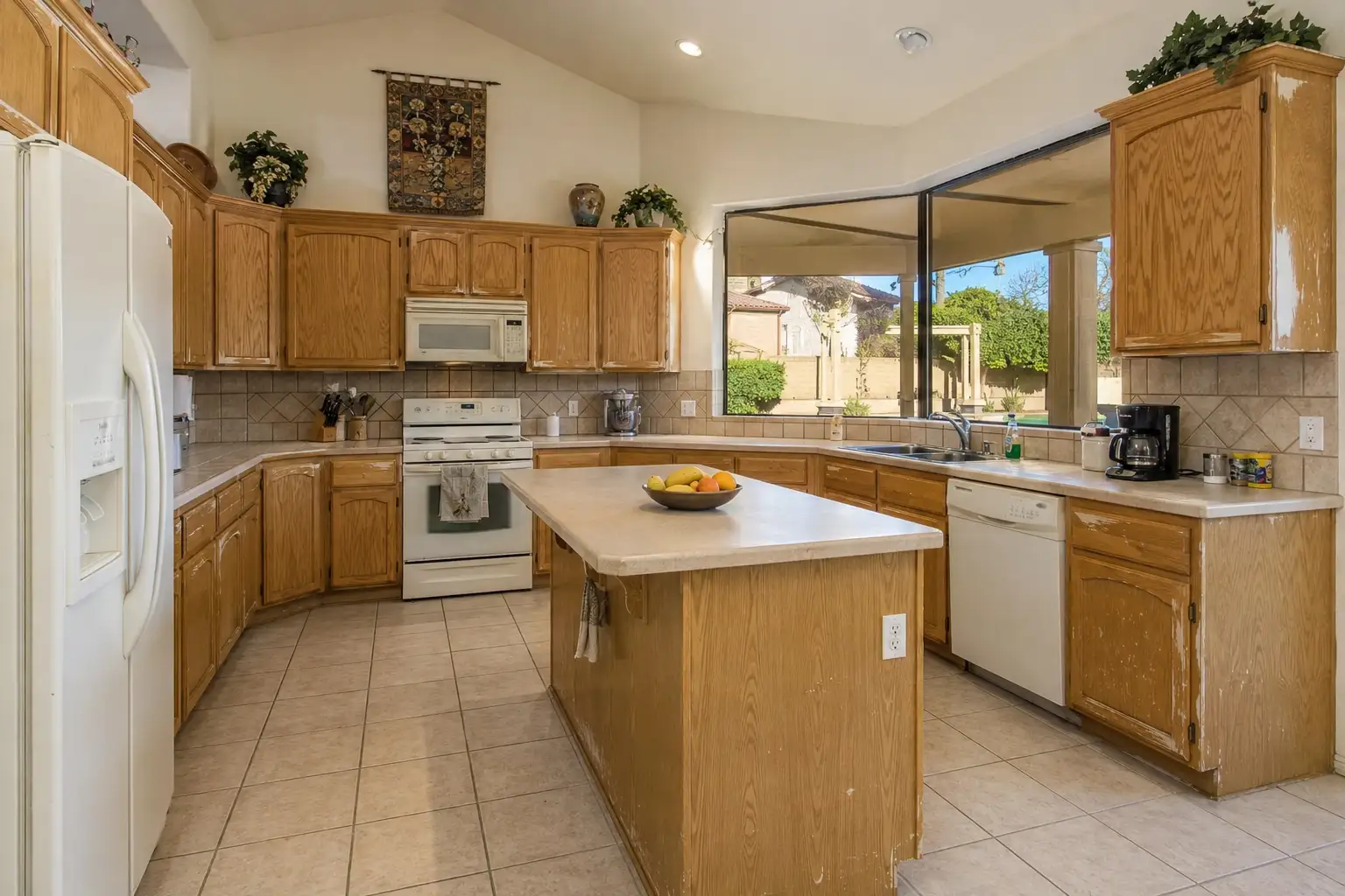 Kitchen Remodeling Scottsdale AZ before full kitchen remodel with outdated oak cabinets, old laminate countertops, worn tile flooring, and aging appliances